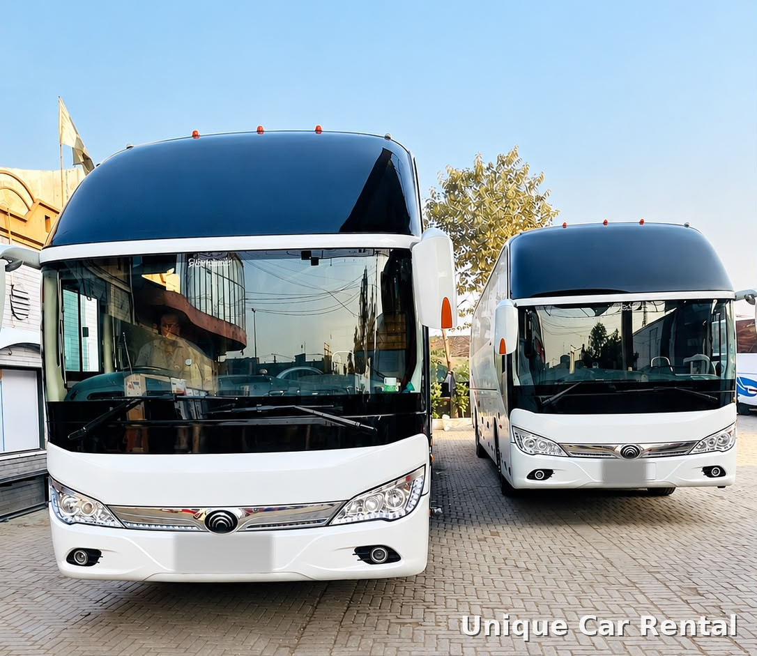 Two white luxury coach buses parked side by side