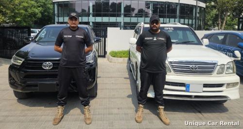 Uniformed security guards standing in front of a Toyota Hilux and Land Cruiser - security guard service in Islamabad