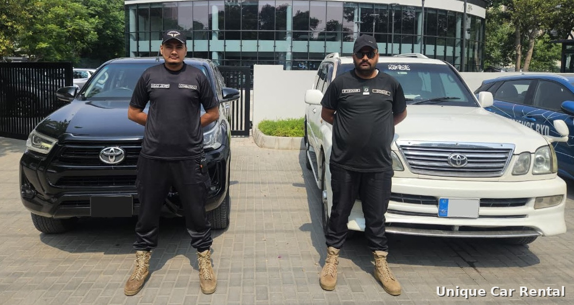 Uniformed security guards standing in front of a Toyota Hilux and Land Cruiser - security guard service in Islamabad