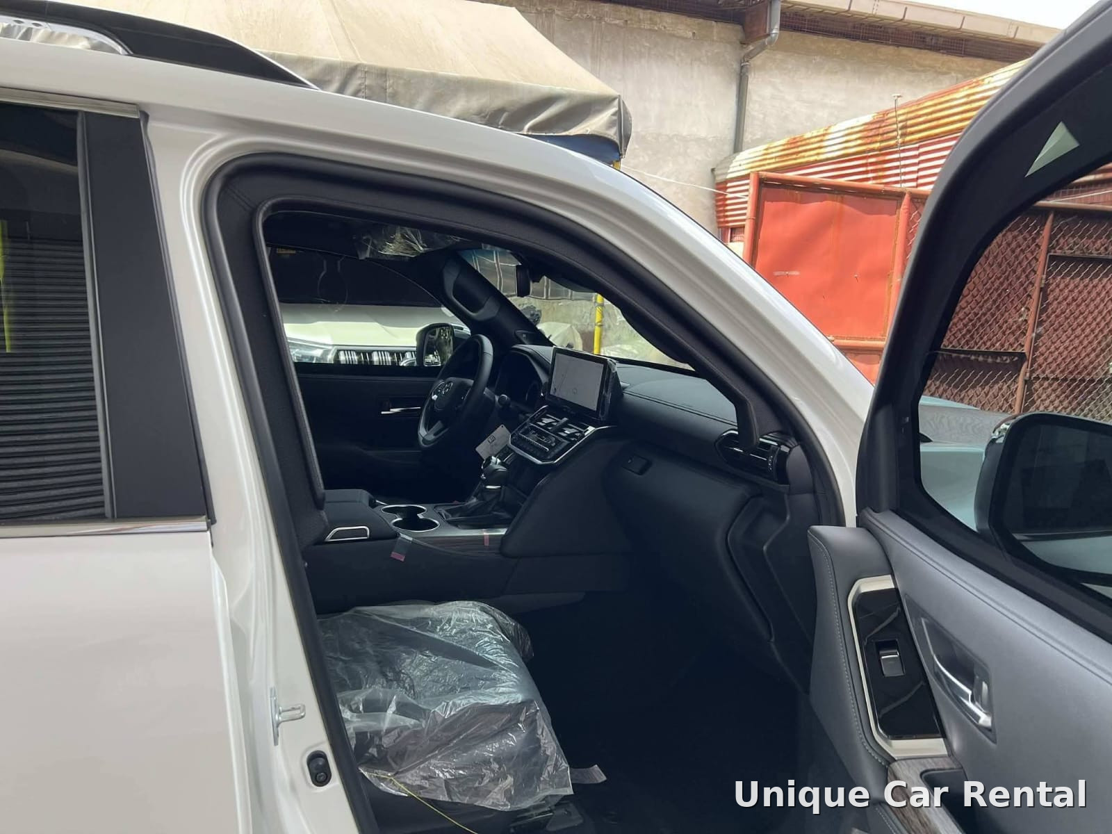 Toyota Land Cruiser 300 interior with front seats and dashboard seen through the open door