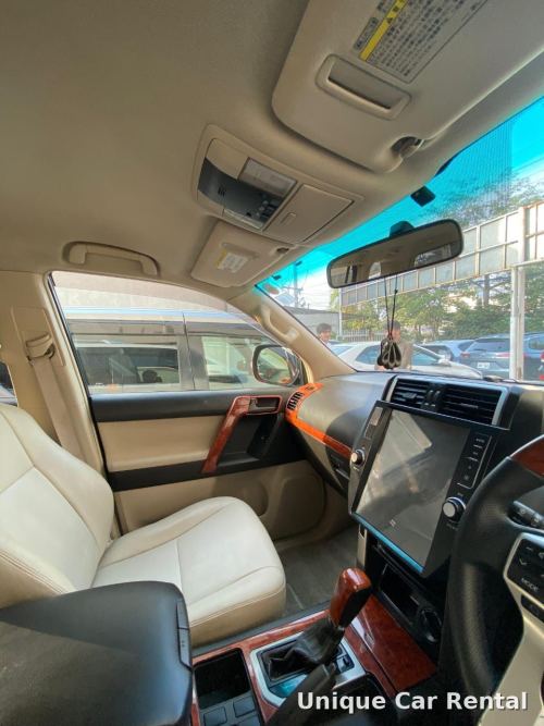 Toyota Land Cruiser Prado interior dashboard with beige leather seats and touchscreen