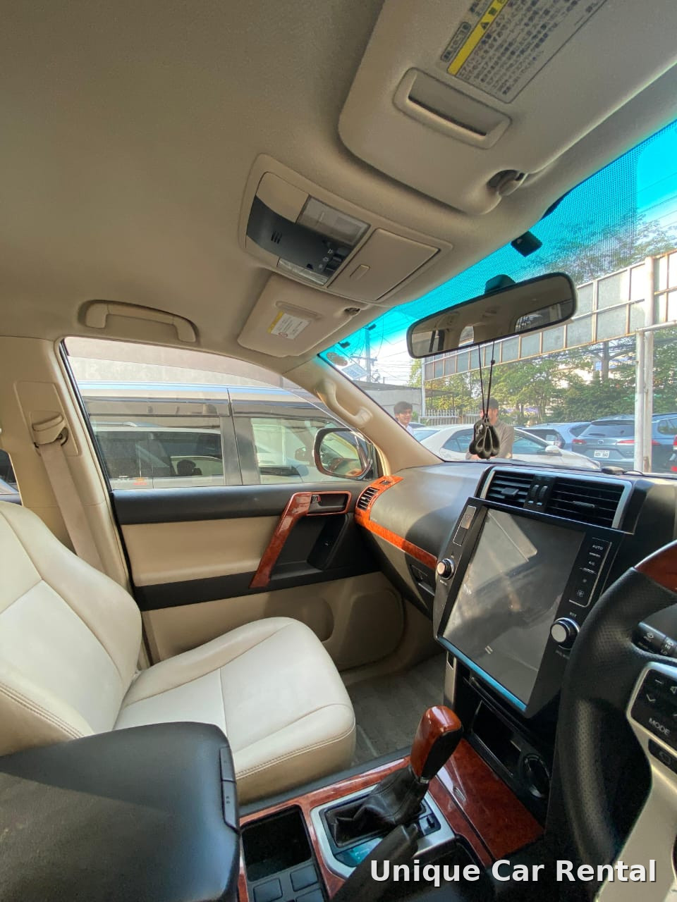 Toyota Land Cruiser Prado interior dashboard with beige leather seats and touchscreen