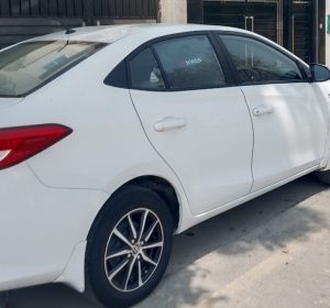 Toyota Corolla on Lahore streets at night with headlights on